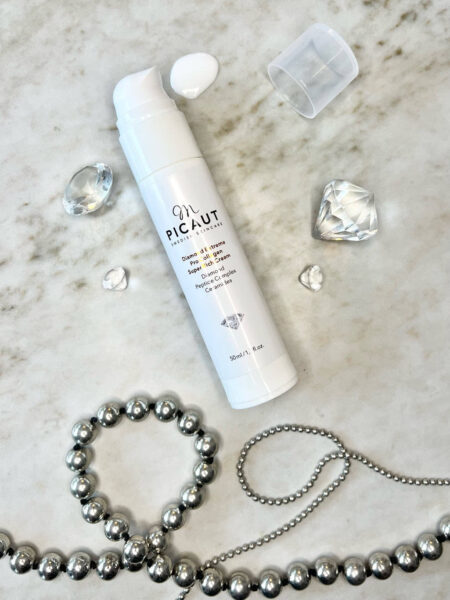 Diamond Extreme Pro Collagen Super Rich Cream från M Picaut Skincare. Ansiktskräm med diamanter och halsband av peptider på marmorskiva.